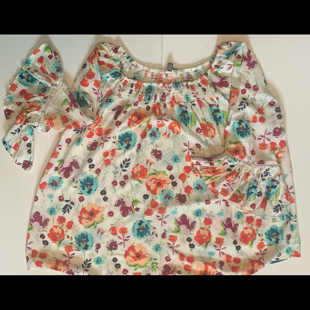White top with colorful floral prints. Round collar to wear around shoulders